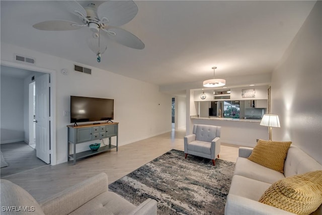 living room with ceiling fan and light wood-type flooring