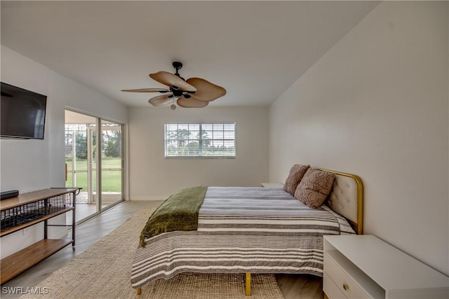 bedroom with ceiling fan, access to exterior, light hardwood / wood-style floors, and multiple windows