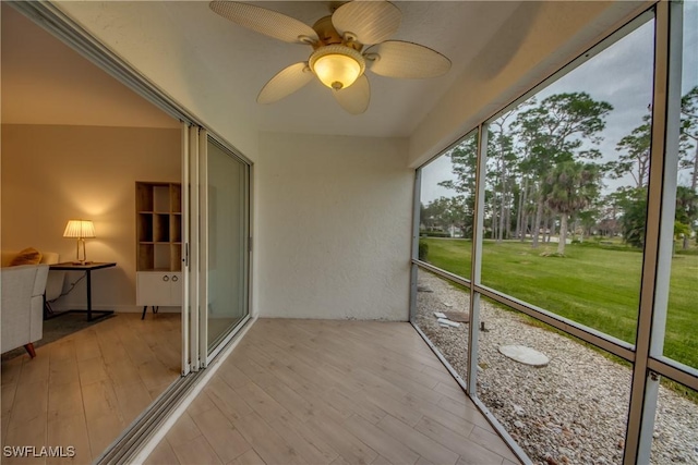 unfurnished sunroom with ceiling fan