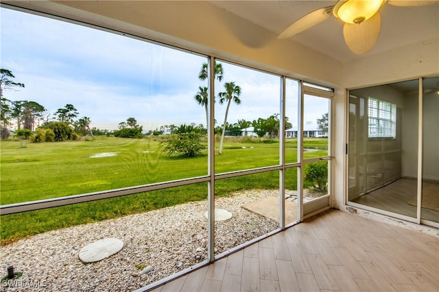 unfurnished sunroom featuring ceiling fan and a healthy amount of sunlight