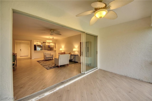 living room with ceiling fan and light wood-type flooring