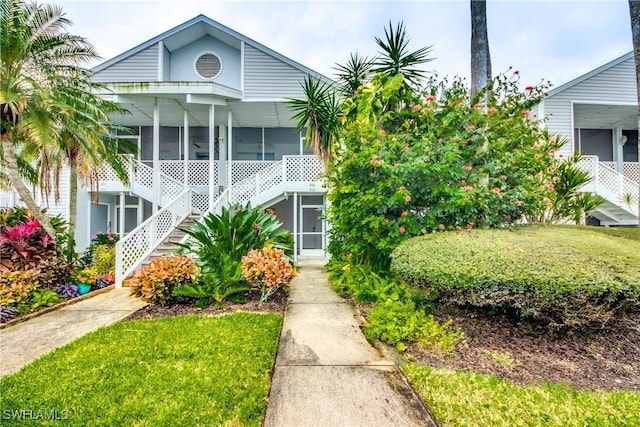 view of front of home featuring a front yard and a sunroom