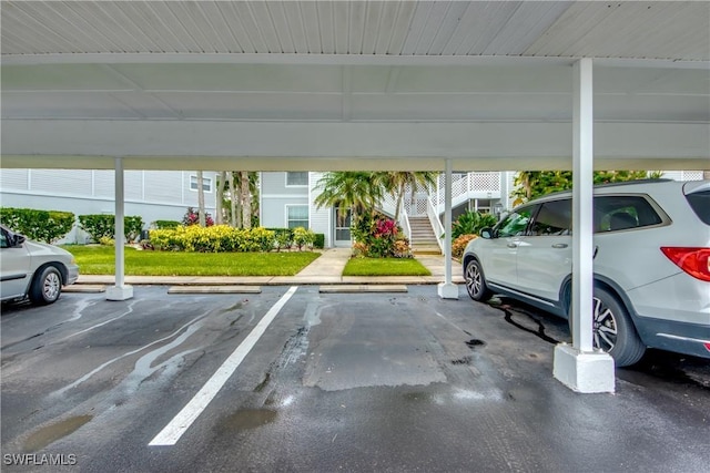 view of vehicle parking with a carport and a yard