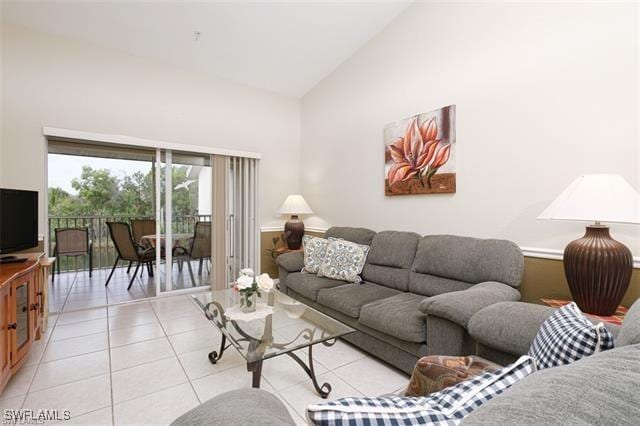 tiled living room featuring high vaulted ceiling