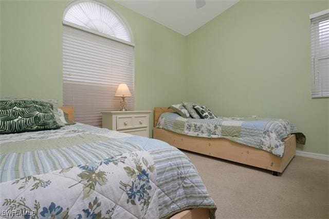 bedroom with vaulted ceiling, light carpet, and ceiling fan