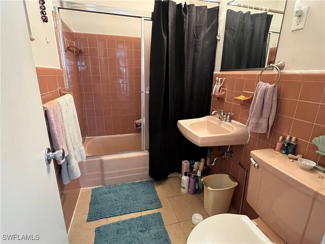 full bathroom featuring sink, tile walls, tile patterned floors, toilet, and shower / bath combo with shower curtain