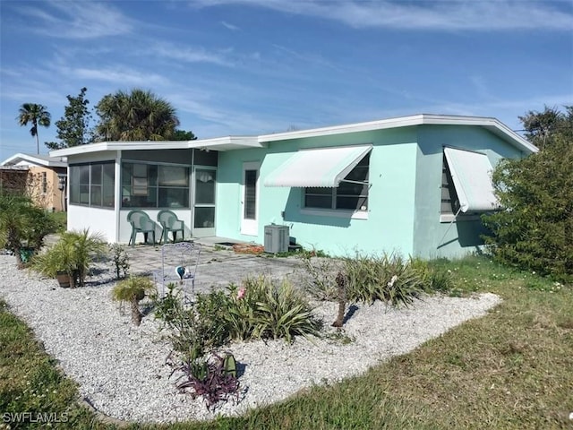 rear view of house with a sunroom, a patio, and central air condition unit