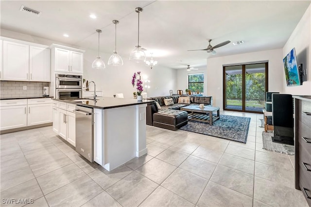 kitchen featuring sink, stainless steel appliances, hanging light fixtures, and white cabinets