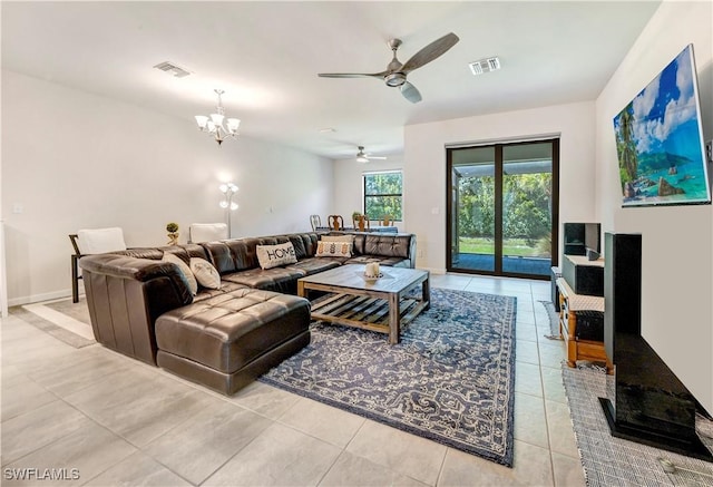 living room featuring ceiling fan with notable chandelier and light tile patterned floors