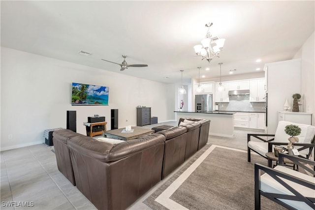 living room with ceiling fan with notable chandelier