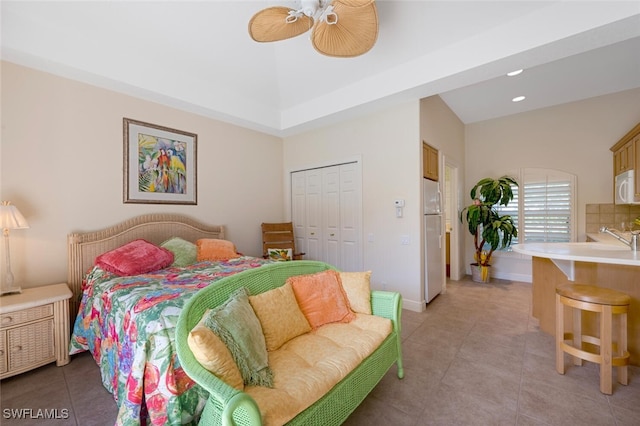 bedroom featuring light tile patterned flooring, a closet, ceiling fan, and white fridge