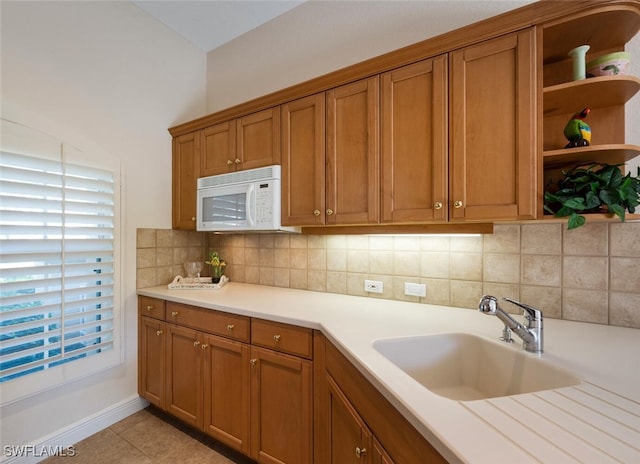 kitchen with sink, backsplash, and light tile patterned floors