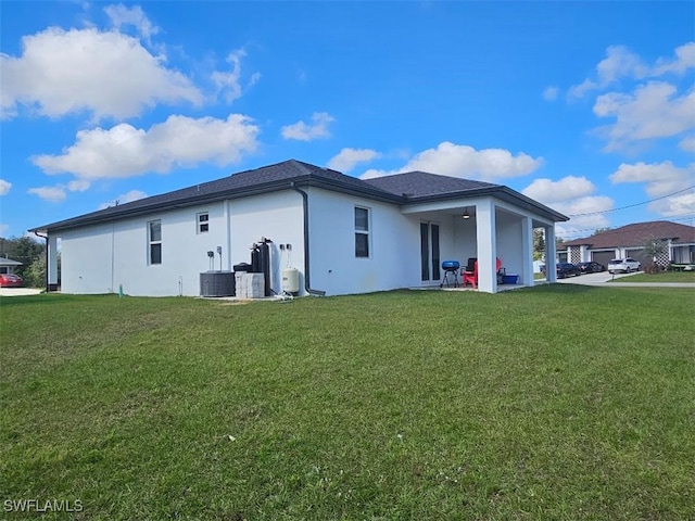 rear view of house featuring a patio, a yard, and cooling unit