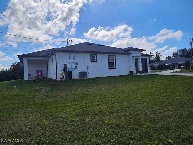 rear view of house featuring a lawn and central air condition unit