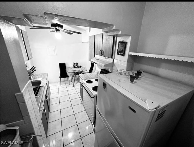 kitchen with light tile patterned flooring, ceiling fan, and fridge