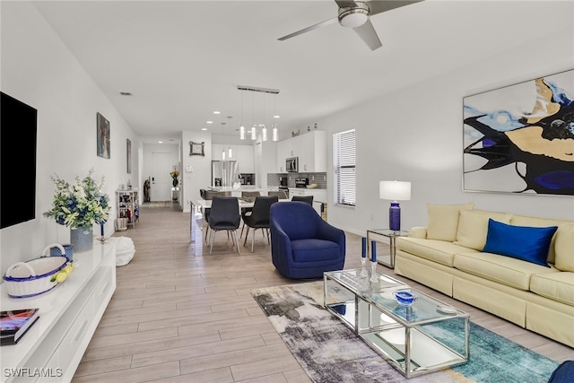 living room featuring ceiling fan and light wood-type flooring