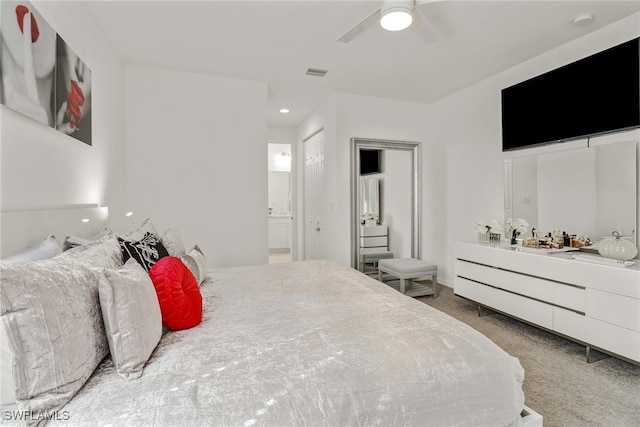 carpeted bedroom featuring ceiling fan and ensuite bath