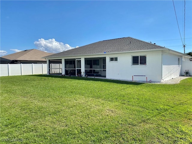 rear view of property with a lawn and a sunroom