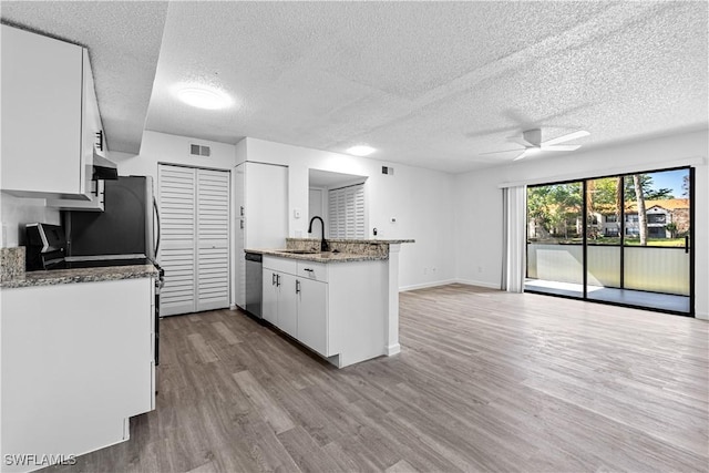 kitchen featuring white cabinetry, sink, stainless steel dishwasher, ceiling fan, and light hardwood / wood-style flooring