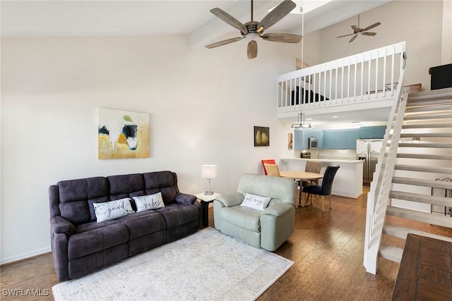 living area with ceiling fan, high vaulted ceiling, wood finished floors, stairs, and beamed ceiling