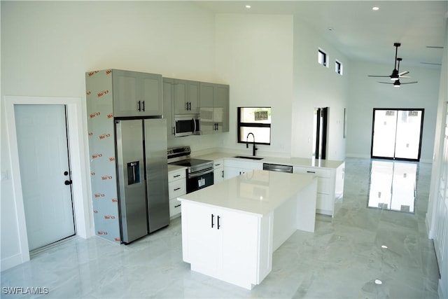 919 Columbus Blvd S, Lehigh Acres, FL 33974 - kitchen featuring stainless steel appliances, a towering ceiling, a sink, light marble finish flooring, and a ceiling fan