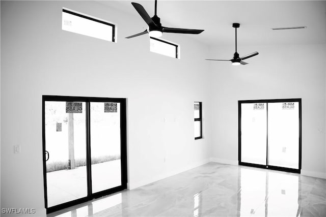 919 Columbus Blvd S, Lehigh Acres, FL 33974 - empty room featuring a ceiling fan, a towering ceiling, light marble finish flooring, and baseboards
