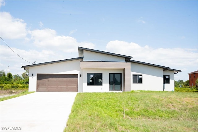 919 Columbus Blvd S, Lehigh Acres, FL 33974 - contemporary house with a garage, stucco siding, concrete driveway, and a front lawn