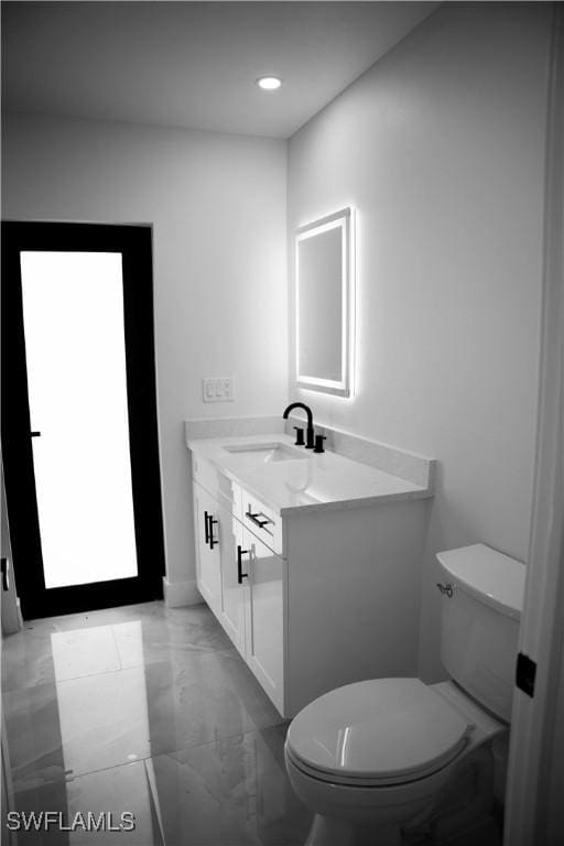 919 Columbus Blvd S, Lehigh Acres, FL 33974 - half bath with marble finish floors, toilet, vanity, recessed lighting, and baseboards