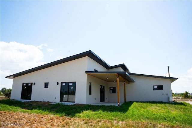 919 Columbus Blvd S, Lehigh Acres, FL 33974 - rear view of property featuring stucco siding and a yard