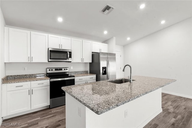 kitchen featuring dark hardwood / wood-style flooring, white cabinetry, stainless steel appliances, and a kitchen island with sink