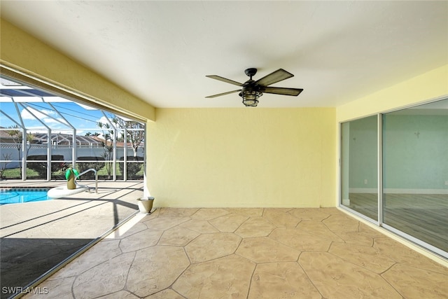 view of patio with a lanai, a ceiling fan, and an outdoor pool