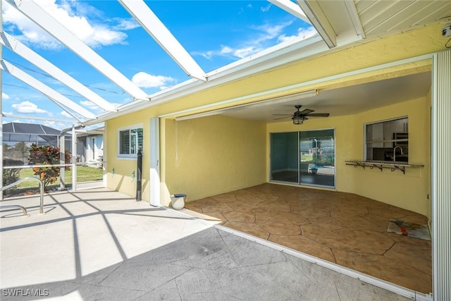 view of patio with glass enclosure and ceiling fan