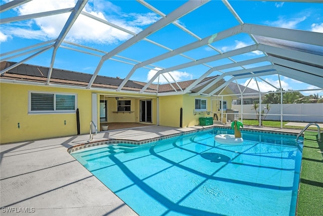 view of swimming pool featuring glass enclosure, a patio area, fence, and a fenced in pool