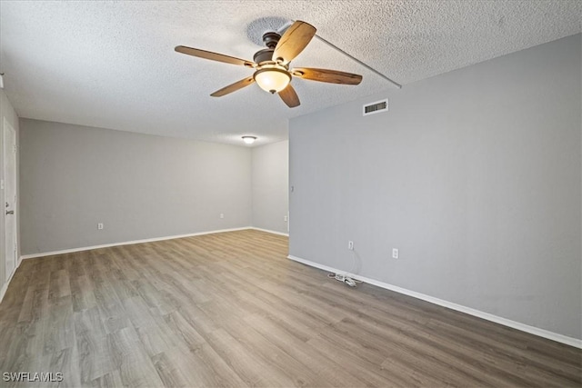 unfurnished room featuring ceiling fan, light hardwood / wood-style flooring, and a textured ceiling