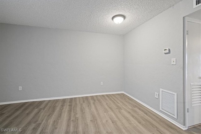 spare room with wood-type flooring and a textured ceiling