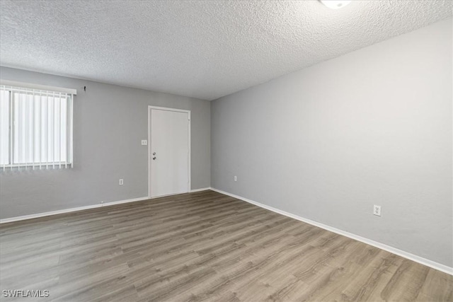 empty room featuring hardwood / wood-style flooring and a textured ceiling