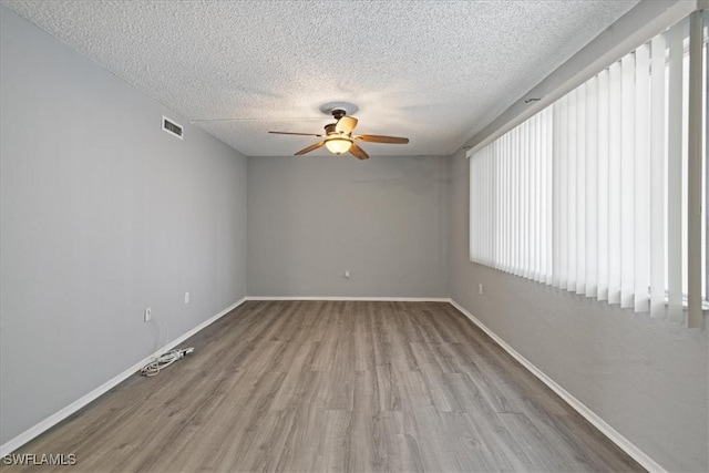 unfurnished room featuring ceiling fan, a textured ceiling, and light wood-type flooring