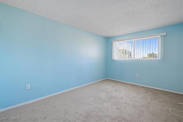 carpeted spare room featuring a textured ceiling