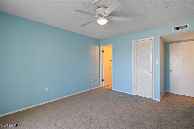 unfurnished bedroom featuring ceiling fan, a closet, carpet flooring, and a textured ceiling