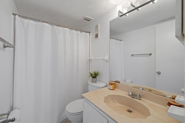 bathroom with walk in shower, vanity, and toilet