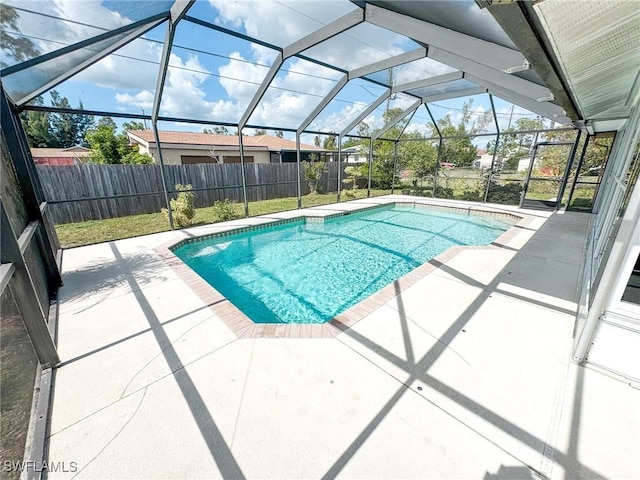 view of pool featuring glass enclosure and a patio area