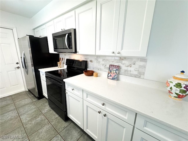 kitchen with tasteful backsplash, tile patterned floors, stainless steel appliances, and white cabinets