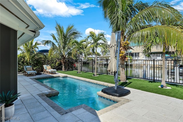 view of pool featuring a water view, a yard, and a patio area