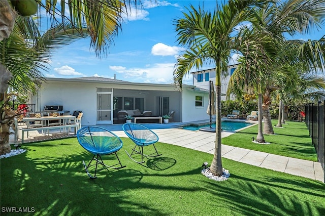 back of house featuring a patio, a sunroom, and a lawn