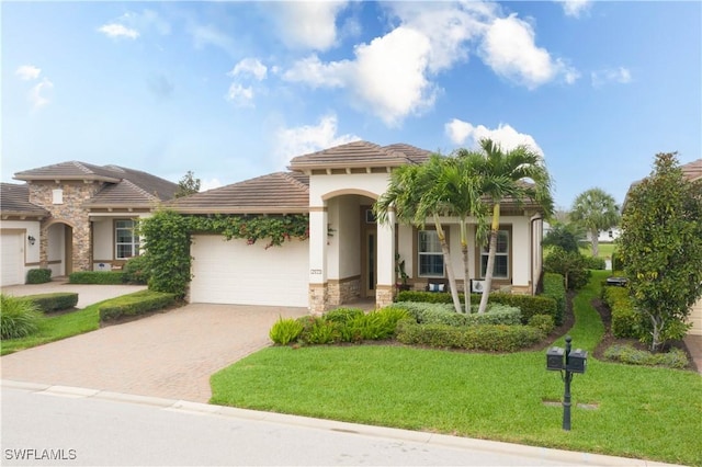 mediterranean / spanish house featuring a garage and a front lawn