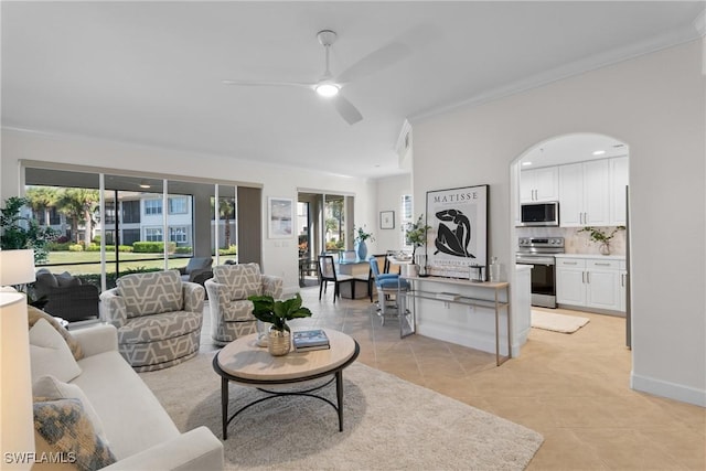 tiled living room with ceiling fan, ornamental molding, and a healthy amount of sunlight