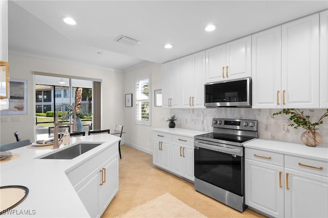 kitchen with stainless steel appliances, sink, white cabinets, and decorative backsplash