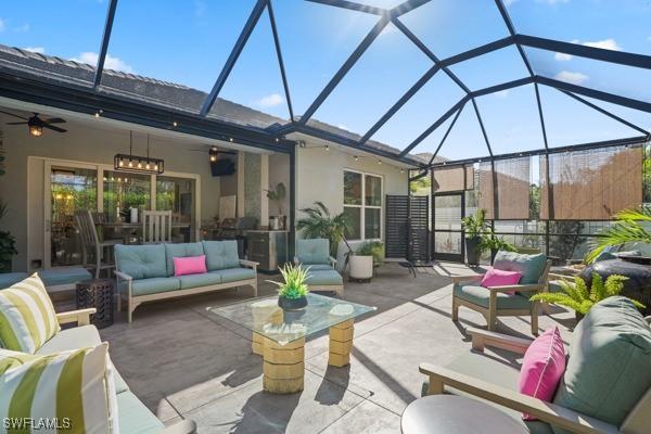 view of patio / terrace featuring outdoor lounge area, glass enclosure, and a ceiling fan