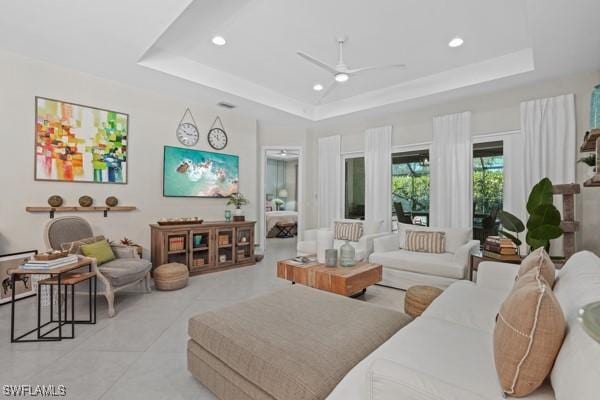 interior space with a ceiling fan and a tray ceiling