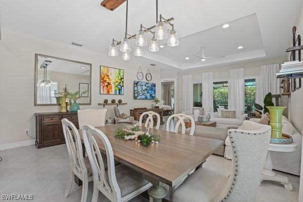 dining room featuring a tray ceiling, recessed lighting, baseboards, and visible vents